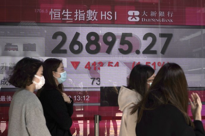 Hongkončania v pondelok 24. februára prechádzajú okolo tabule zobrazujúcej čerstvý prepad hodnoty akcií. Foto - AP