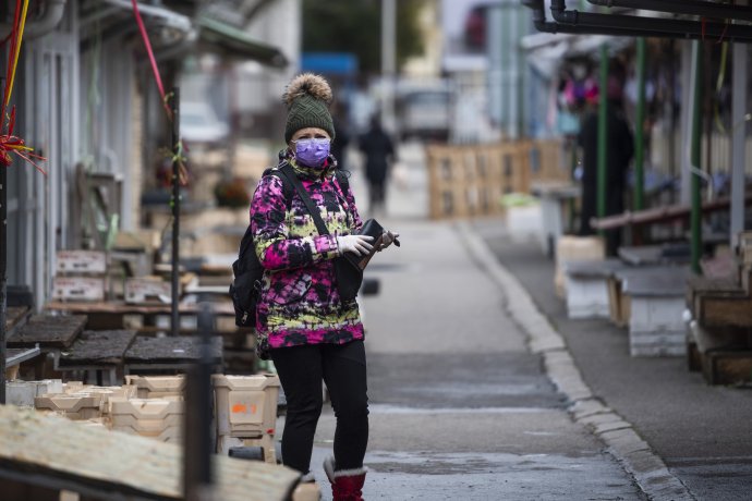 Žena s rúškom na trhovisku na Miletičovej ulici po jeho zatvorení. Foto – TASR