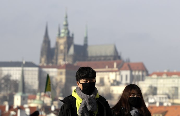 Turisti majú na tvári ochranné rúška počas návštevy Karlovho mosta v Prahe. Foto - tasr/ap