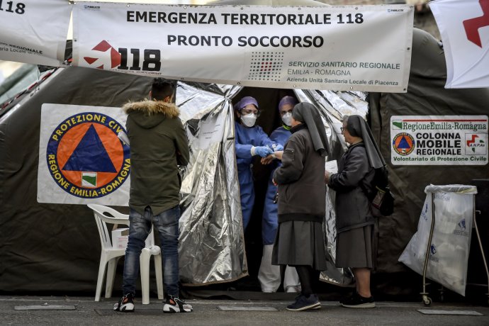 Mníšky sa rozprávajú so zdravotníkmi v stane pred nemocnicou v meste Piacenza. Foto - TASR/AP