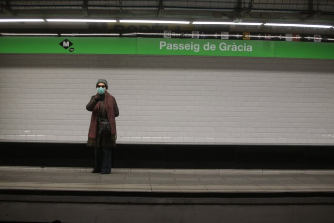 Osamelá cestujúca s rúškom na vlakovej stanici v Barcelone. Foto - TASR/AP