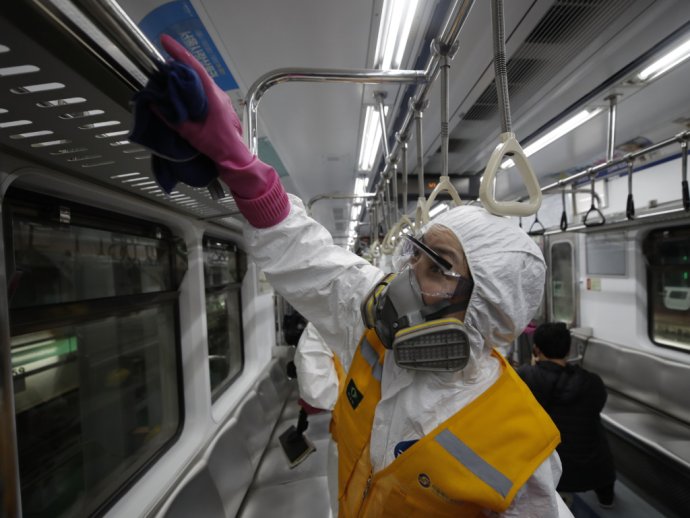 Pracovník v ochrannom obleku dezinfikuje vagón metra proti koronavírusu v Soule. Foto - TASR/AP