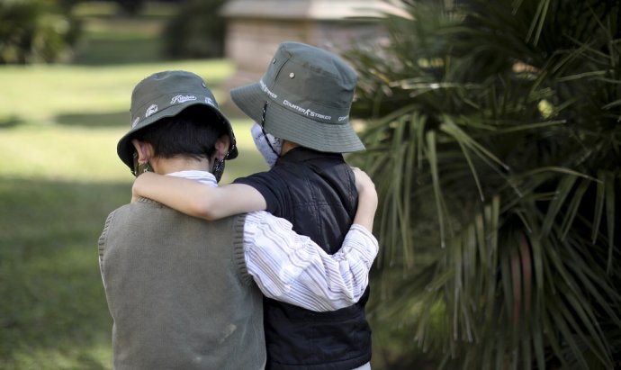 Deti s rúškami na tvárach sa držia v parku v Buenos Aires. Ilustračné foto - TASR/AP