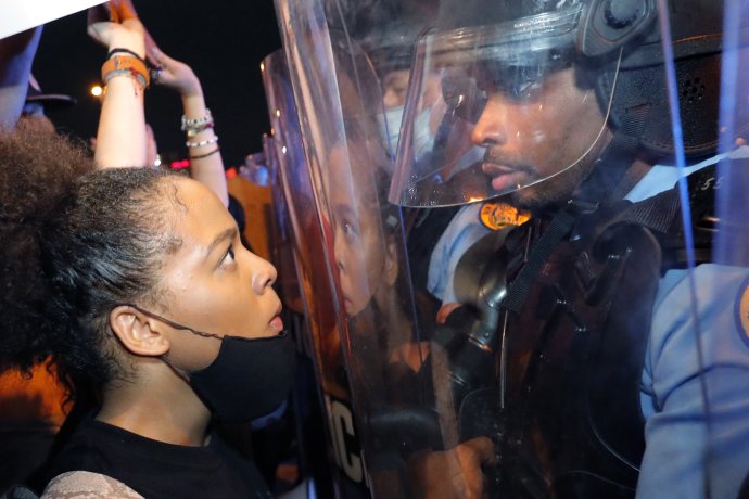 Demonštrantka a policajt v New Orleans. Foto - TASR/AP