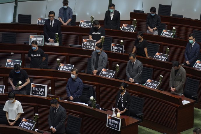 Demokratickí poslanci v hongkonskom zastupiteľstve držia minútu ticha za obete masakru na námestí Tchien-an-men v roku 1989. Foto - TASR/AP