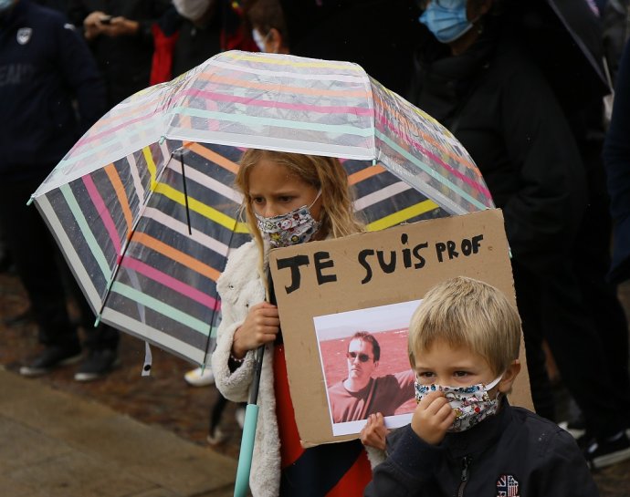 Dievča na demonštrácii v Lille drží transparent s fotografiou Patyho a nápisom: "Som profesor." Foto – TASR/AP