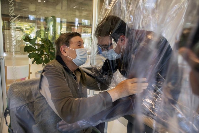 V domove dôchodcov v talianskom Castelfranco Veneto môžu príbuzní prísť objať seniorov cez plastovú záclonu, aby sa vyhli nákaze koronavírusom. Ilustračné foto - TASR/AP