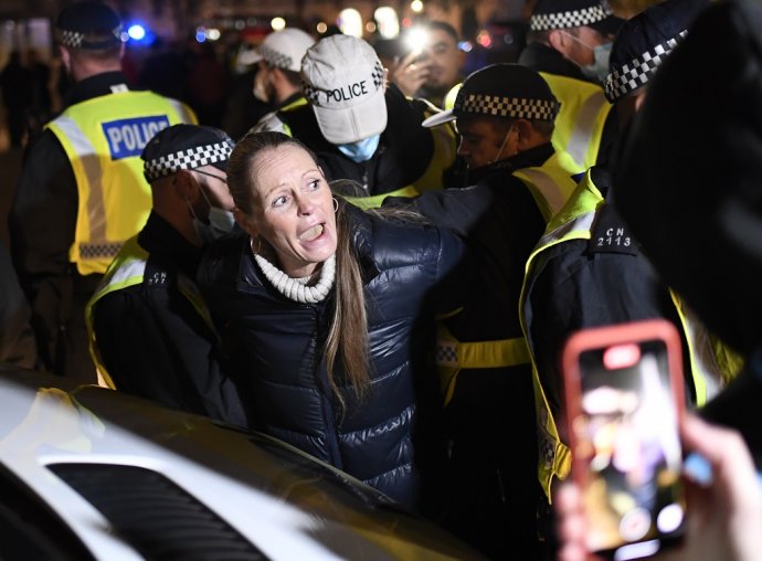 Polícia zatýka ženu počas protestov proti opatreniam na boj s koronavírusom v Londýne. Ilustračné foto - TASR/AP