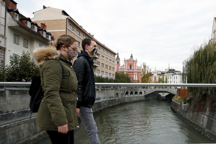 Ľudia prechádzajú cez most v hlavnom meste Slovinska Ľubľana. Foto - TASR/AP