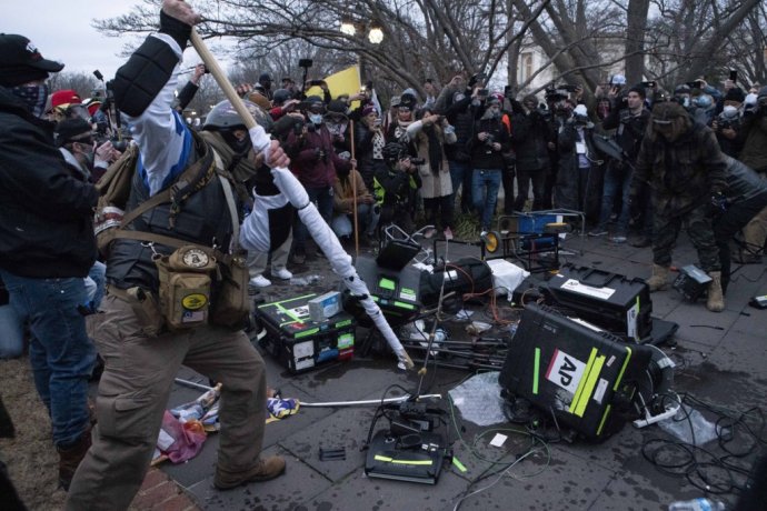 Demonštranti rozbíjajú pred budovou Kapitolu novinárom techniku. Foto - TASR/AP