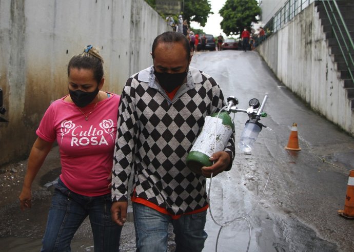 Rafael Pereira s manželkou nesie do nemocnice kyslíkovú bombu, ktorú kúpil pre svoju svokru hospitalizovanú v nemocnici v Manaus. Foto: TASR/AP