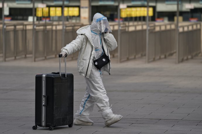 Žena v ochrannom obleku na pekinskej železničnej stanici. Foto - TASR/AP