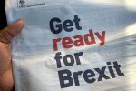 Ruka držiaca britské noviny s titulkom "Get ready for Brexit"