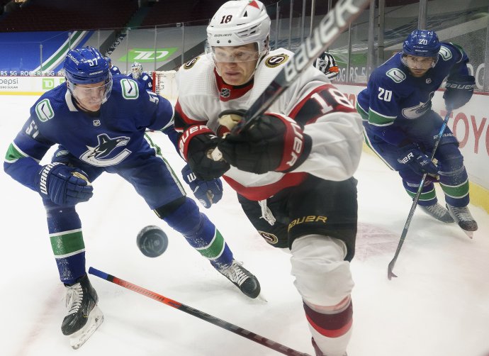 Tim Stützle bojuje o puk proti hráčom Vancouveru. Foto - TASR/AP