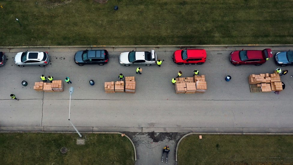 Dobrovoľníci v Pensylvánii nakladajú balíky s jedlom do kufrov pristavených áut. Foto - Washington Post/Zoeann Murphy
