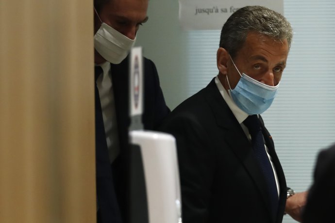 Bývalý francúzsky prezident Nicolas Sarkozy s ochranným rúškom odchádza zo súdu v Paríži. Foto - TASR/AP