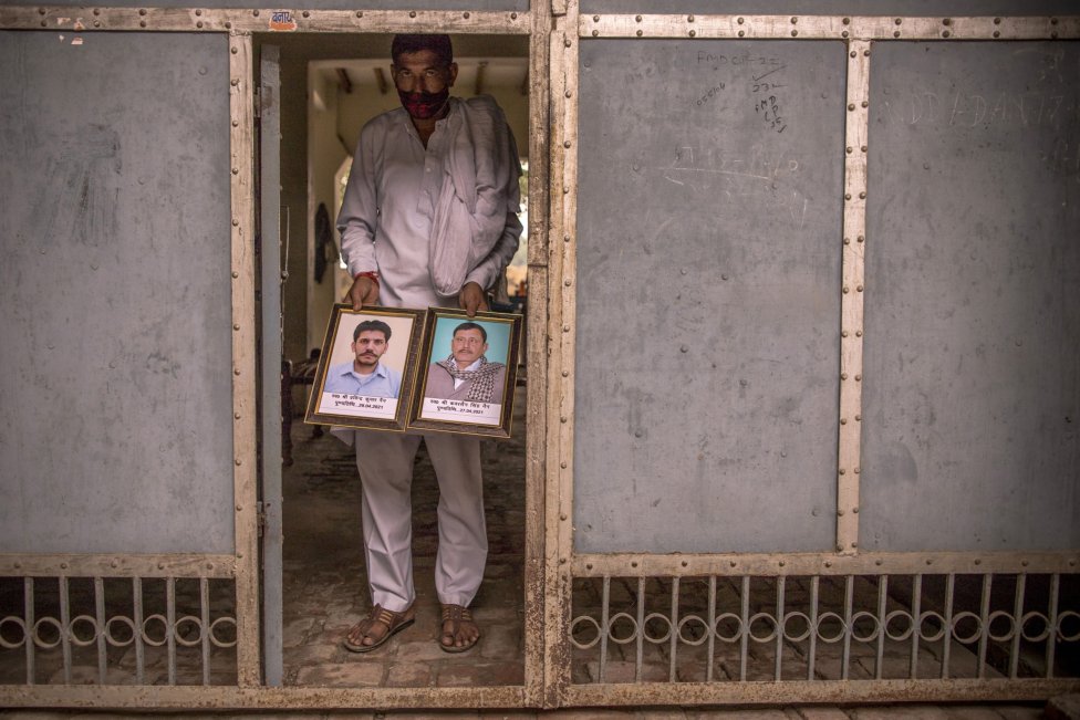 Sanjeev Kumar s portrétmi svojho brata a otca, ktorí covidu podľahli. Foto – Bloomberg/Anindito Mukherjee