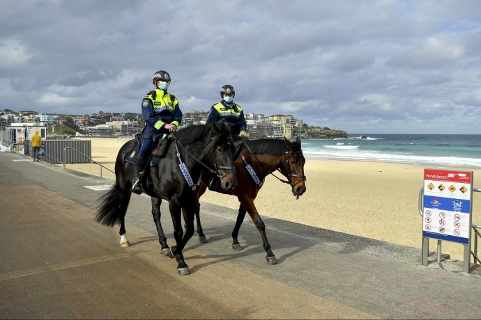 Policajti na pláži v Sydney kontrolujú dodržiavanie opatrení proti covidu. Foto - TASR/AP