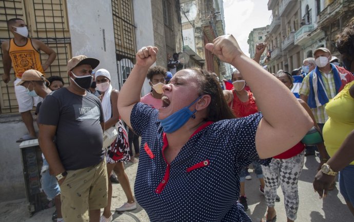 Žena na protestoch proti kubánskej vláde kričí provládne heslá, kým protivládni demonštranti pochodujú ulicami Havany. Foto -TASR/AP