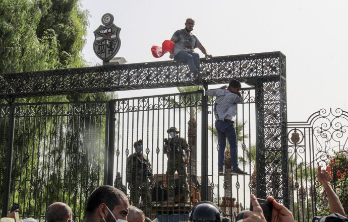 Demonštranti protestujú pred tuniským parlamentom, ktorý strážia vojaci. Foto: TASR/AP