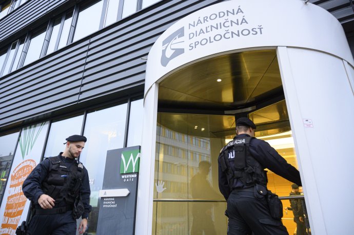 Policajti vstupujú do budovy, kde sídli aj Národná diaľničná spoločnosť v Bratislave, 16. decembra 2019. Foto – TASR