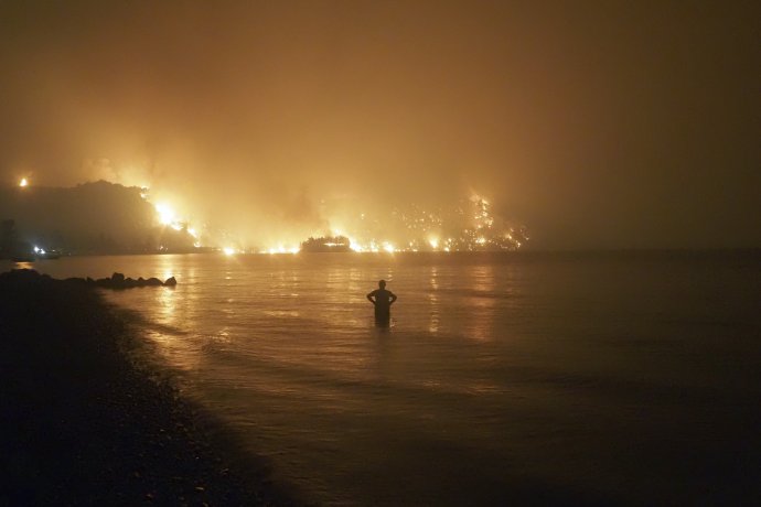 Muž sleduje požiar neďaleko pláže Kochyli na ostrove Euboia zhruba 160 kilometrov od Atén. Foto –TASR/AP