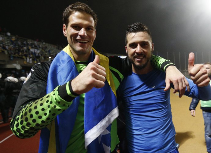 Asmir Begović (vľavo) a Haris Medunjanin sa radujú z víťazstva v Litve, ktorým si Bosna zabezpečila postup na MS 2014. Foto - TASR/AP