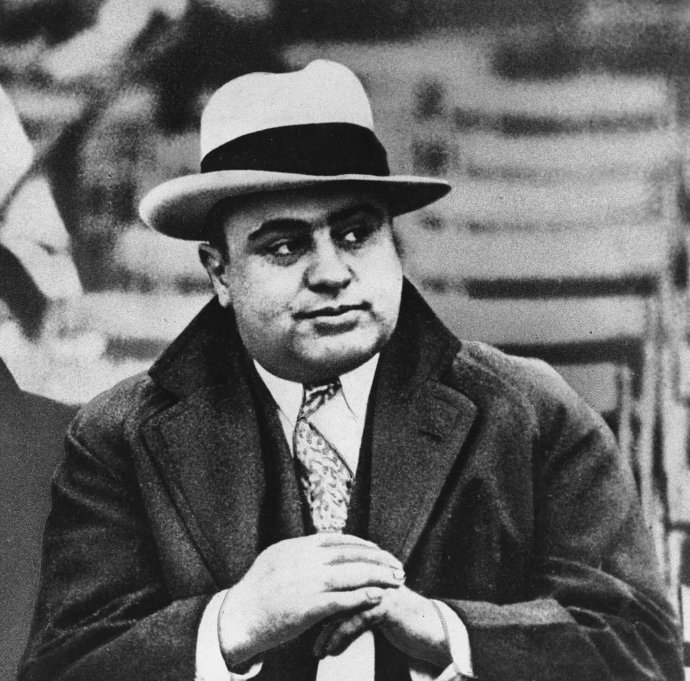 Na archívnej snímke z 19. januára 1931 slávny chicagsky gangster Al Capone sleduje futbalový zápas v Chicagu. Ešte v ten rok skončil vo väzení. Foto - TASR/AP
