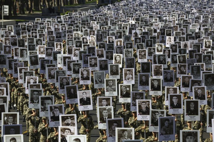 Azerbajdžanskí vojaci nesú fotografie vojakov, ktorí prišli o život vo vojne o Náhorný Karabach. Presné číslo obetí Baku tají. Foto - TASR/AP