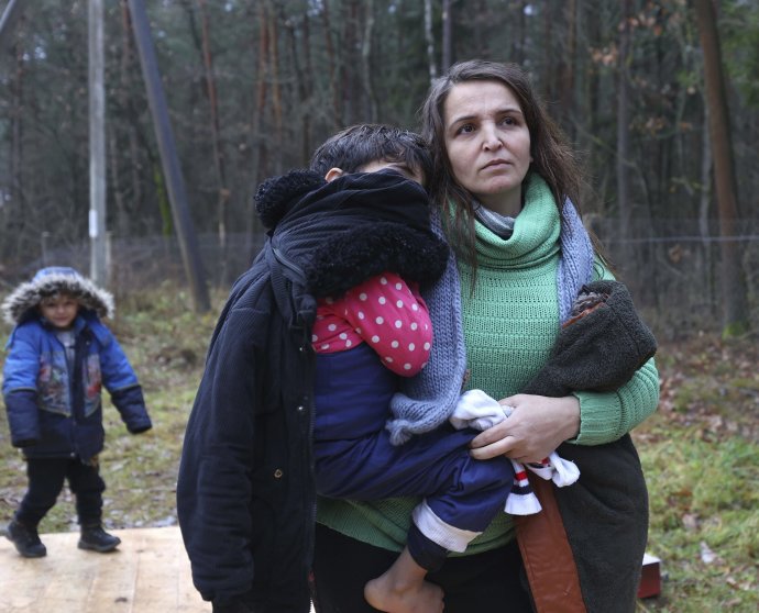 Žena z Blízkeho východu so svojím dieťaťom na bieloruskej strane hranice. Foto - TASR/AP