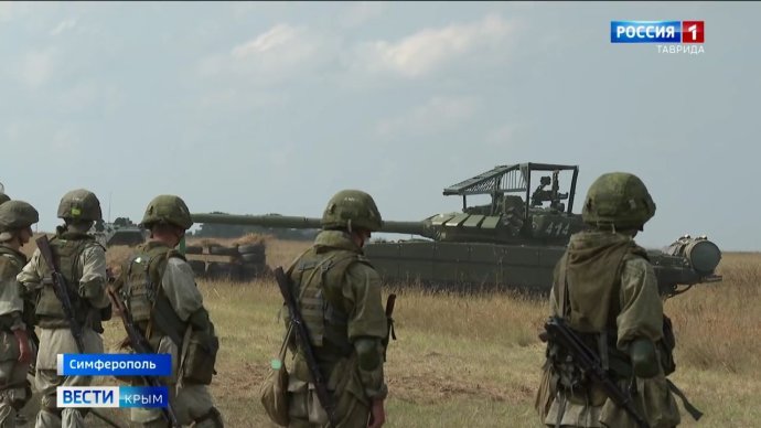 Ruskí vojaci na Kryme si obzerajú tank s dodatočnou ochranou proti útokom zhora
