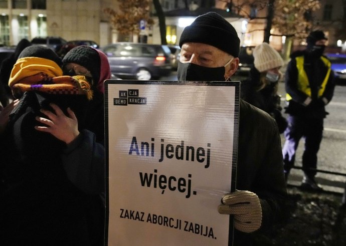 Muž drží transparent s nápisom "Ani o jednu viac" na protestoch proti zákonu o potratoch v stredu 26. januára 2022 pred budovou ústavného súdu vo Varšave. Foto - TASR/AP