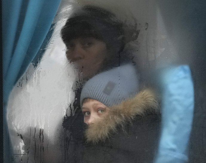 Vojna na Ukrajine zasiahla milióny ľudí. Žena s dieťaťom opúšťajú Sjevjerodoneck v Luhanskej oblasti. Foto - TASR/AP
