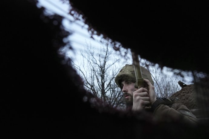Ukrajinský vojak počúva delostreleckú paľbu v zákopoch na frontovej línii. Foto - TASR/AP