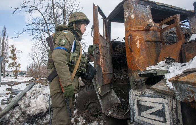 Ukrajinský vojak obhliada zničenú ruskú techniku. Foto - TASR/AP