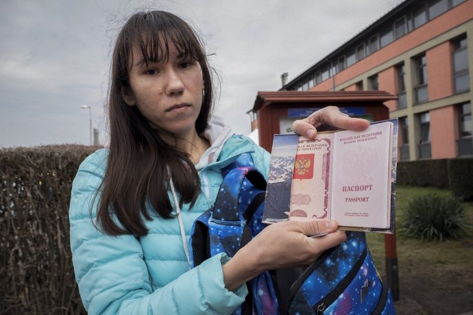 Ruská občianka Olena ukazuje svoj cestovný pas. Pred Putinovým režimom pred pár rokmi ušla do Kyjiva, teraz je na úteku znovu. Foto - TASR/AP