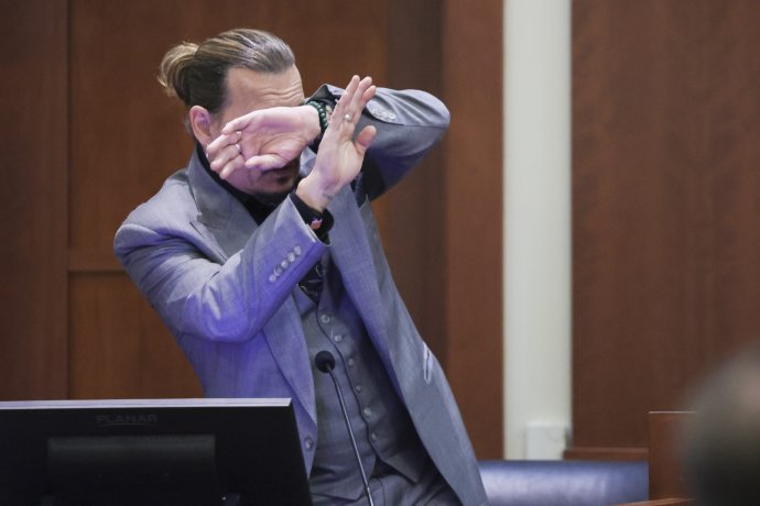 Johnny Depp pred súdom demonštruje, ako sa chránil pred údajným útokom svojej bývalej manželky. Foto - TASR/AP