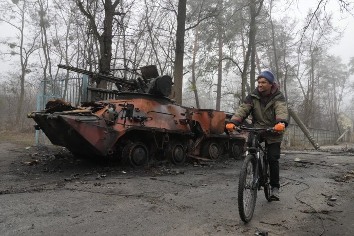 Miestny obyvateľ ide na bicykli okolo zničeného vojenského bojového vozidla pechoty v meste Irpiň, z ktorého sa stiahla ruská armáda. Foto - TASR/AP