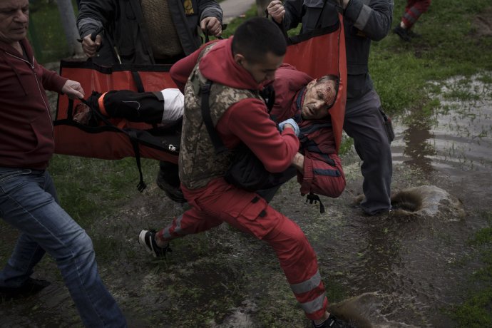 Záchranári odvážajú zraneného Charkivčana po ruskom ostreľovaní. Foto - TASR/AP