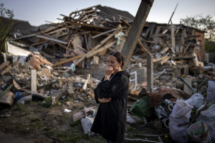 Egy nő a lebombázott háza előtt Irpinyben. Fotó - TASR/AP