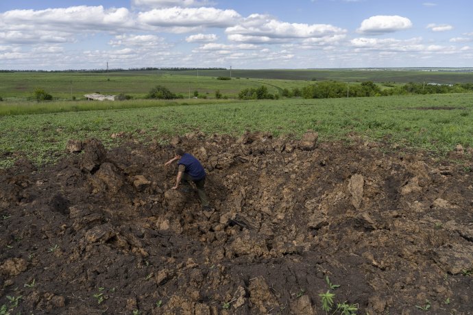 Farmárske práce v kráteri po výbuchu neďaleko Charkiva. Foto - TASR/AP