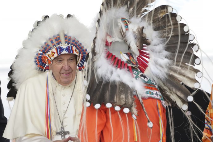 Pápež František (vľavo) má na hlave tradičnú čelenku, ktorú dostal po ospravedlnení sa pôvodným obyvateľom počas obradu v meste Maskwacis v Kanade. Foto - TASR/AP