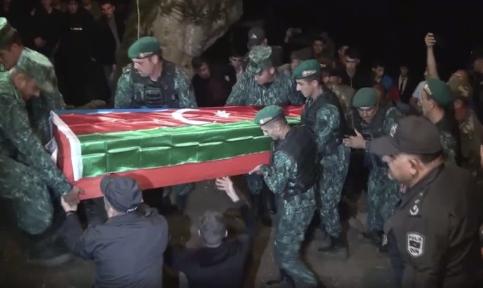 Azerbajdžanskí vojaci nesú rakvu so zabitým kolegom, ktorý zahynul počas útoku na Arménsko. Foto - TASR/AP