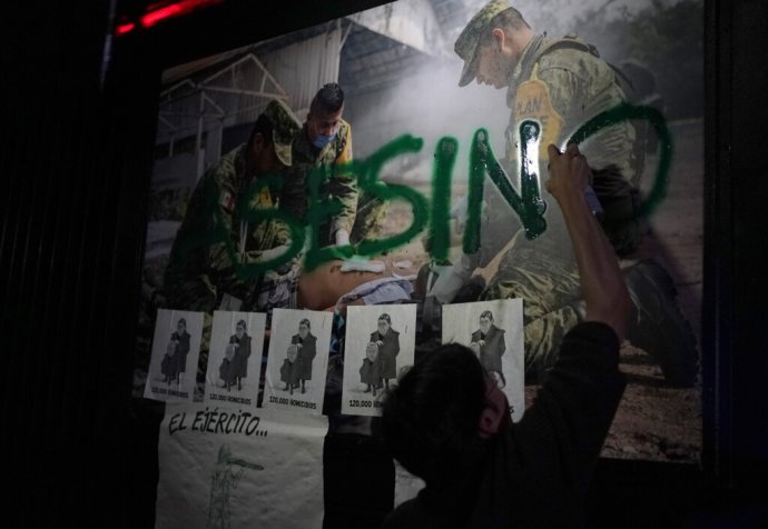 Demonštrant napísal „Vrah“ v španielčine sprejom na stenu počas pochodu smerom k senátu na protest proti prezidentovmu návrhu presunúť civilnú Národnú gardu pod operačnú a administratívnu kontrolu ministerstva obrany v Mexicu City, utorok 9. 6. 2022. Návrh prešiel mexickou dolnou komorou minulý týždeň a vyvolal obavy z militarizácie bezpečnosti Mexika. Foto – TASR/AP