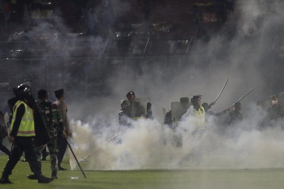 Policajti a vojaci uprostred oblaku slzného plynu. Foto - TASR/AP