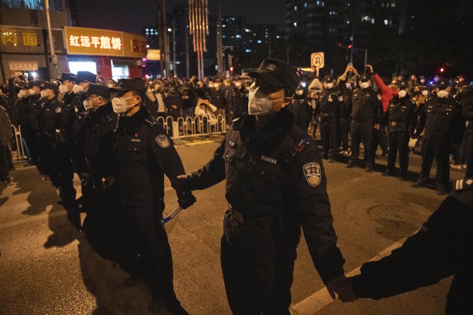 Čínski policajti sa snažia zastaviť demonštrantov v Pekingu. Foto - TASR/AP