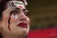 Iránka plače po tom, čo jej príslušník bezpečnostnej zložky odobral vlajku s nápisom "Ženy, život, sloboda" pred začiatkom zápasu základnej B-skupiny Wales - Irán na MS vo futbale. Foto - TASR/AP