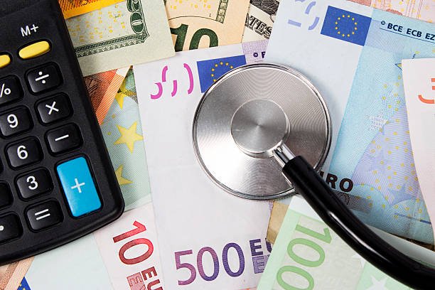 Stethoscope, banknotes and pocket calculator