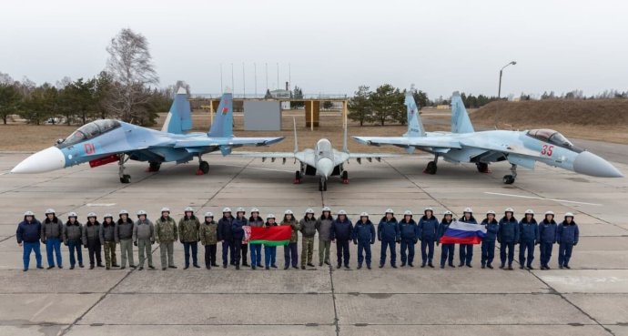 Balra a belarusz Szu-30, jobbra az orosz Szu-35. Köztük egy belarusz MiG-29 vadászrepülőgép, amilyen ukrán oldalon is harcol a modernebb típusok ellen. A fénykép a belarusz bázist ábrázolja, és az ukrán légierő helyzetét jelképezi.