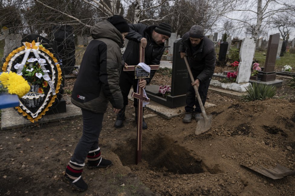 Členovia rodiny umiestňujú kríž na hrob Serhija, ktorý žil len dva dni. Foto - Heidi Levinová/The Washington Post
